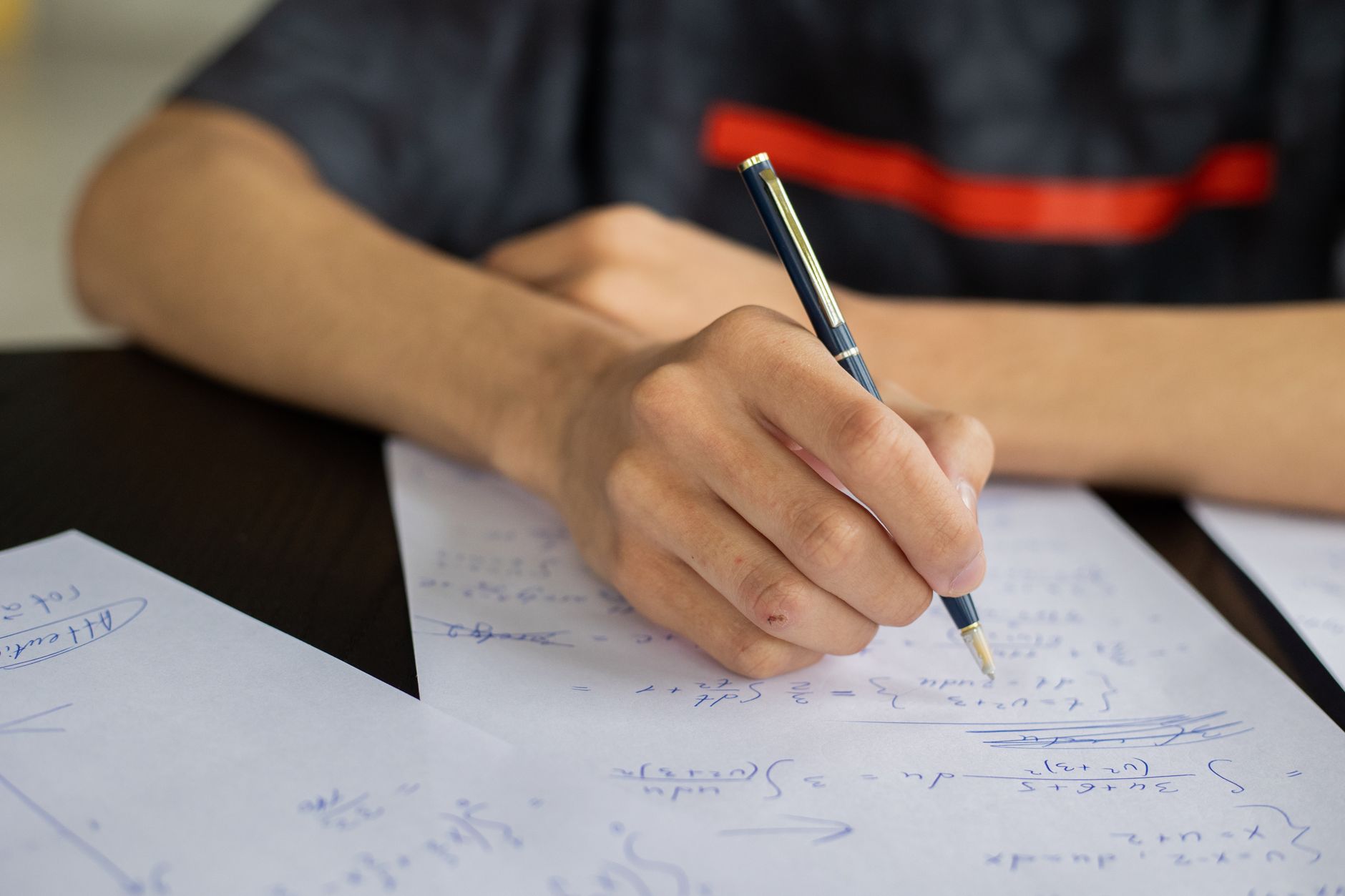 crop man writing on paper while studying