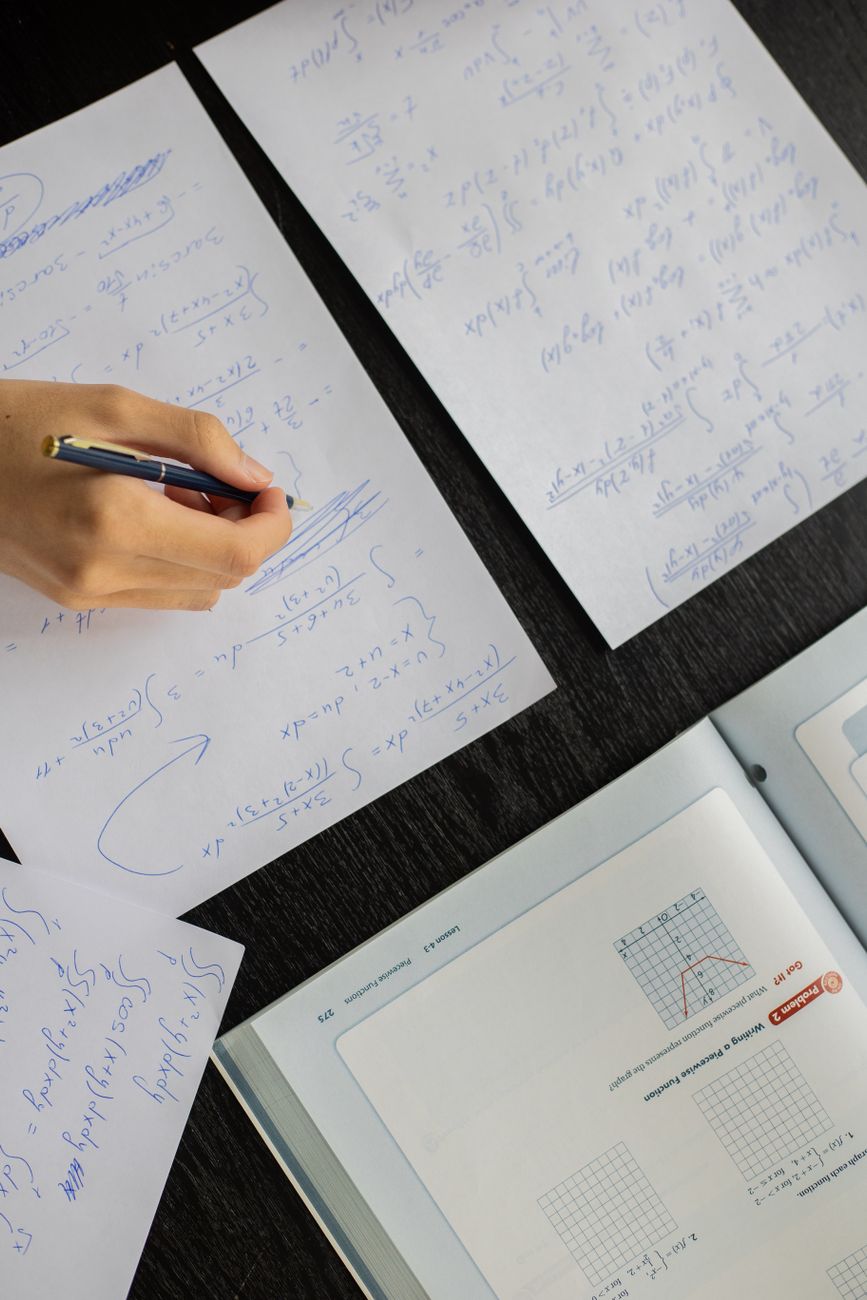 student writing in papers with homework task